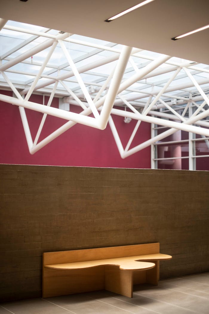 Contemporary interior with geometric ceiling structure and modern furniture.
